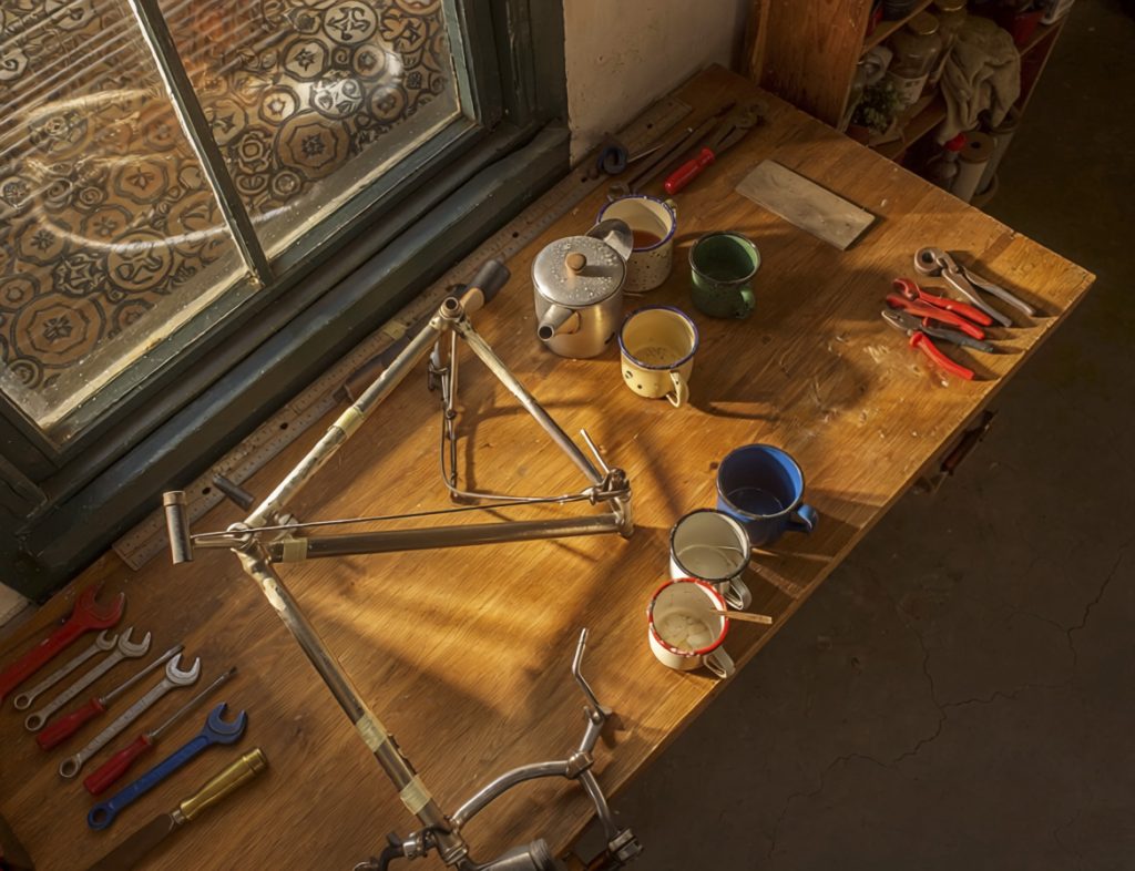 A workbench with tools laid out for several pairs of hands.